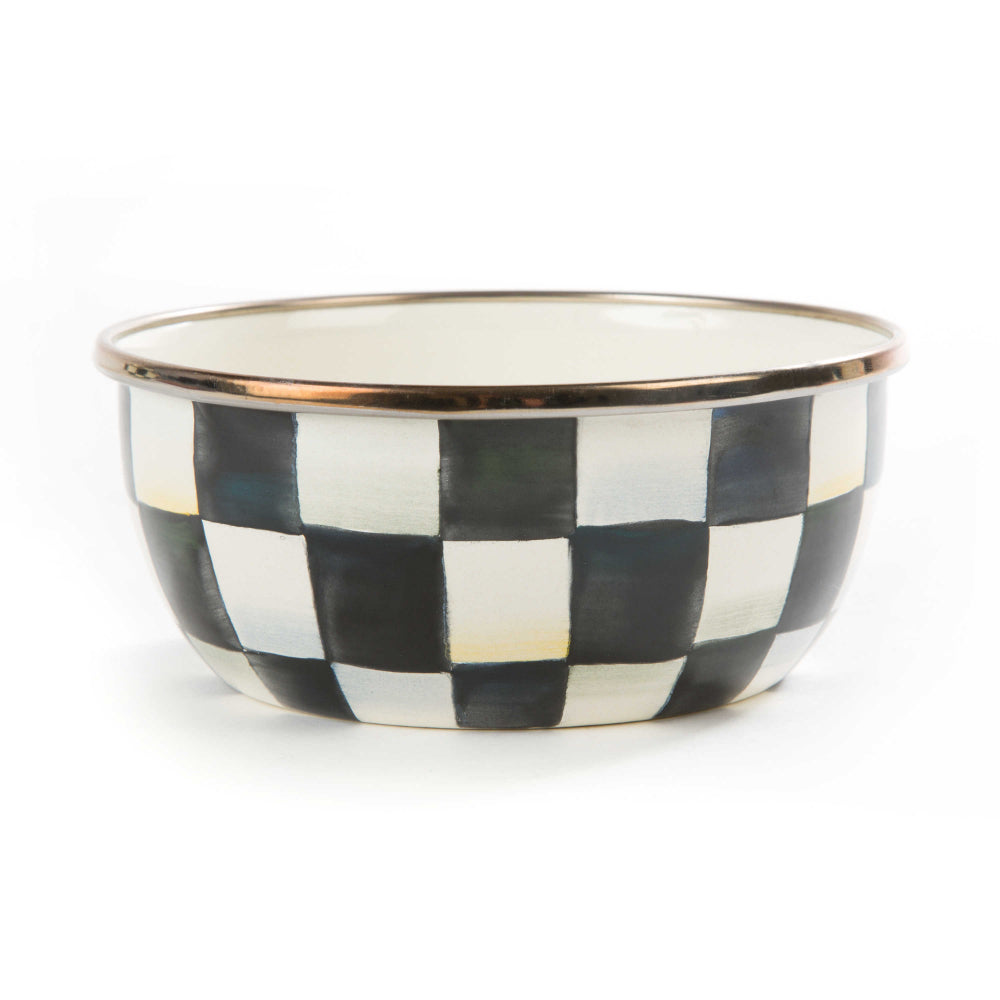 A small, black and white checkered enamel pinch bowl with a bronzed stainless steel rim.