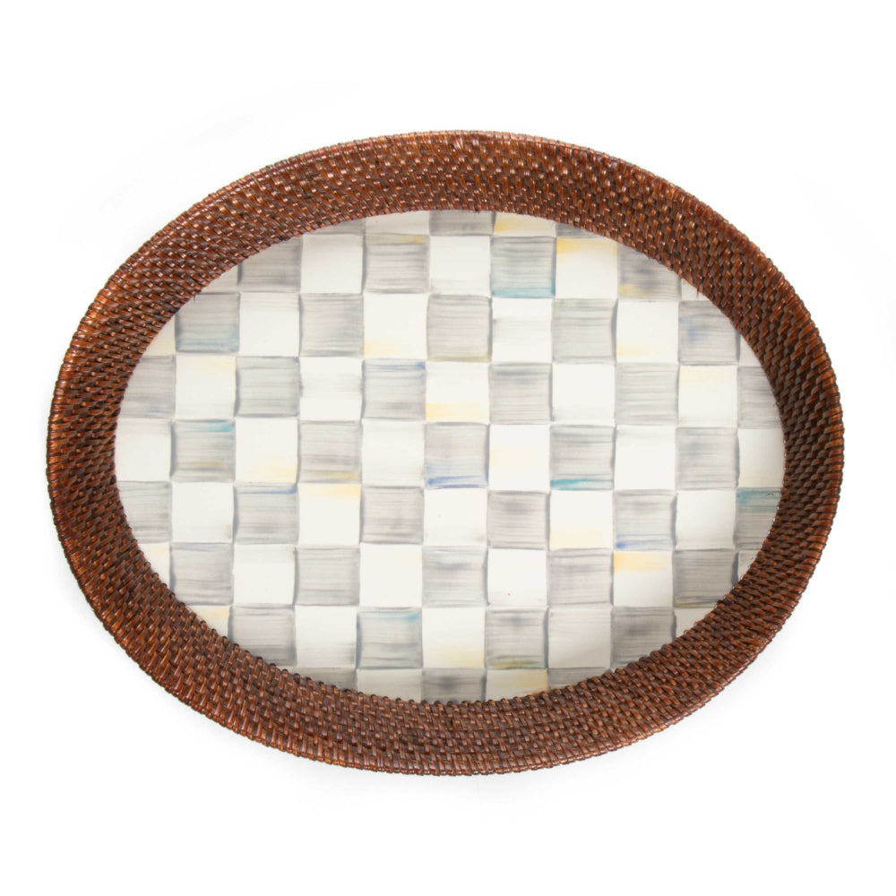 Top veiw of a large round woven tray with a brown rim on a sterling grey checkered pattern bottom on a white background