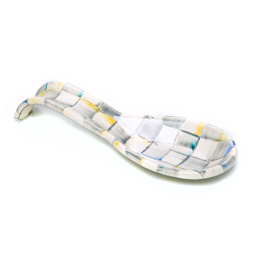 Decorative glass spoon rest with geometric pattern on a white background