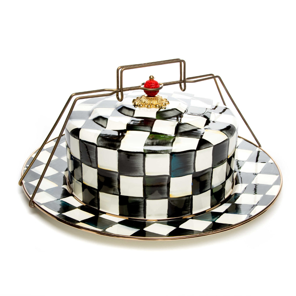 Black and white checkered cake stand with a decorative red & gold  lid on a white background
