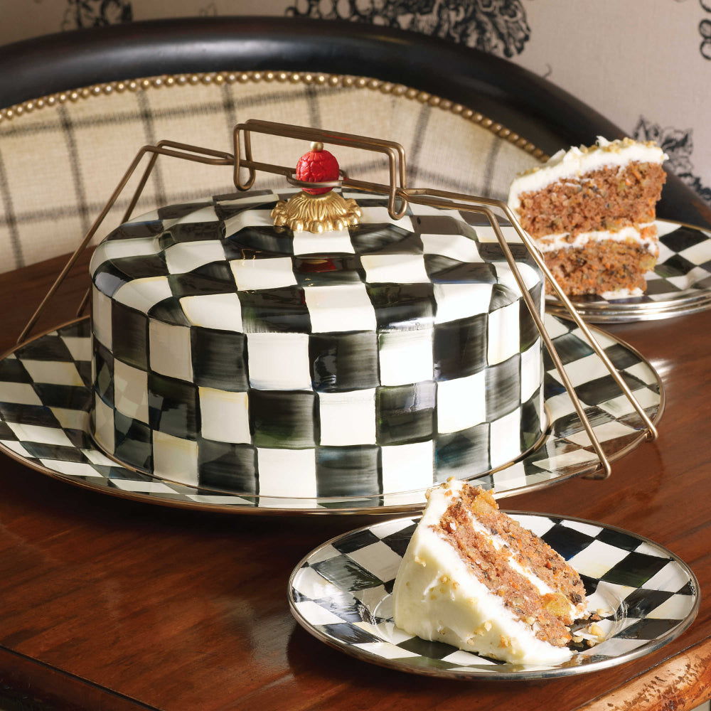 MacKenzie-Childs Courtly Check Enamel Cake Carrier on a wood table with courtly check patterned plates with cake slices on them