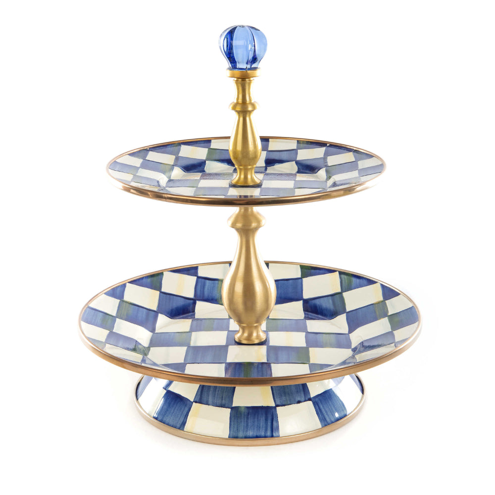 Two-tiered serving tray with royak blue and white checkered design and gold accents on a white background