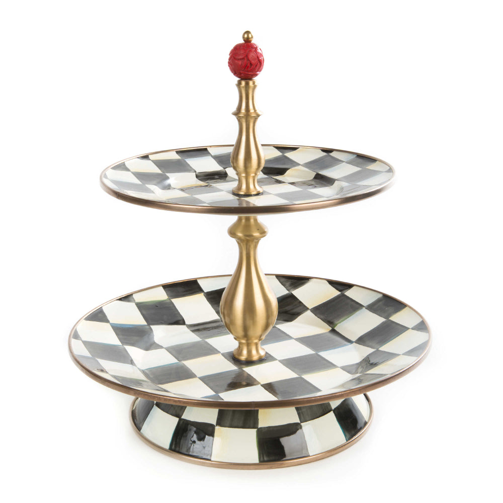 Two-tiered serving tray with black and white checkered design and gold accents on a white background