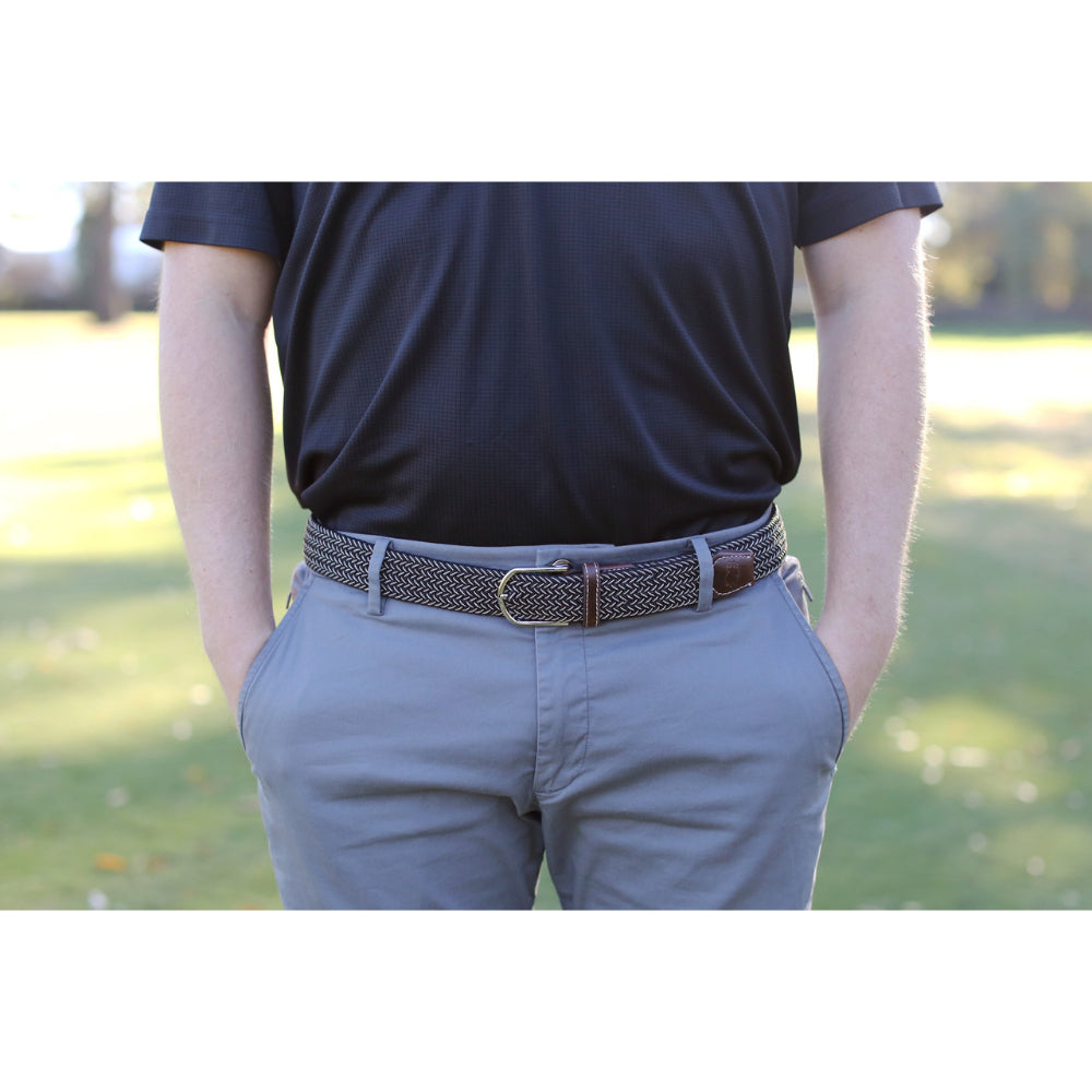 Person wearing woven belt in outdoors with black shirt on.