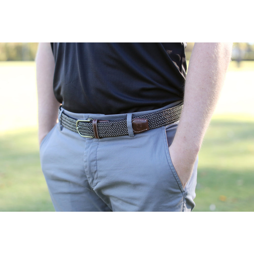 Person wearing woven belt in outdoors with black shirt on.