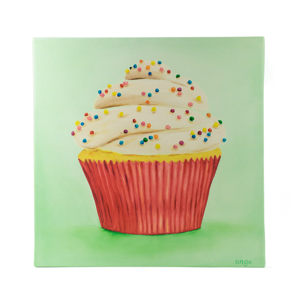 Cupcake with white frosting and colorful sprinkles on a green background.