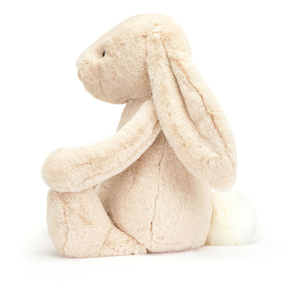 A plush toy resembling a bunny with a beige color, long ears, and a soft fur texture. The bunny has a simple, friendly facial expression with a nose detailed with sparkling thread.