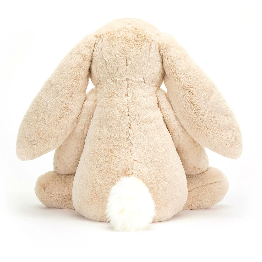 A plush toy resembling a bunny with a beige color, long ears, and a soft fur texture. The bunny has a simple, friendly facial expression with a nose detailed with sparkling thread.