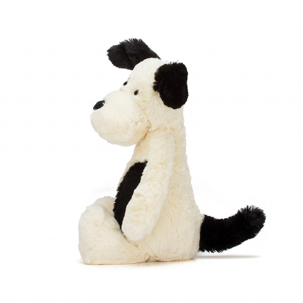 A side photo of the original/medium size Jellycat Bashful Black and Cream Puppy on a white backround.