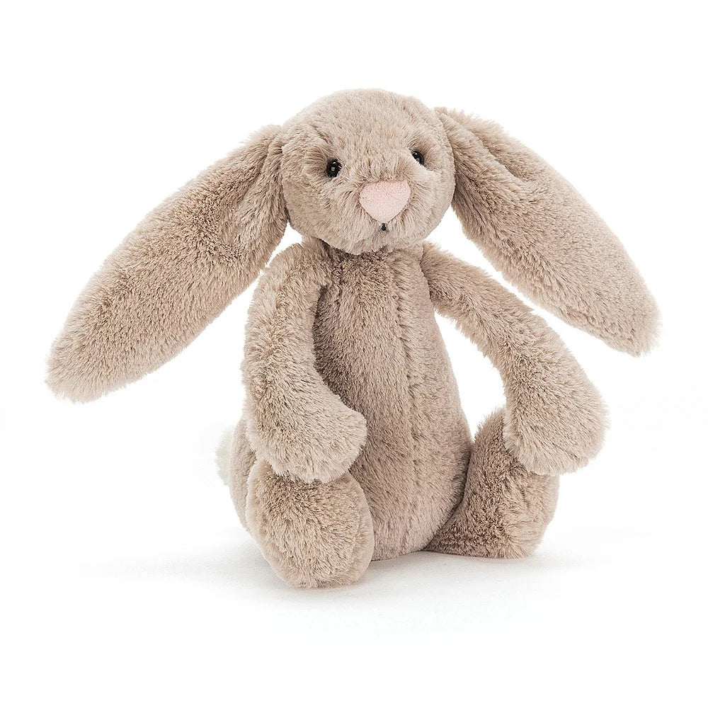 A small size  beige plush toy in the shape of a bunny with long floppy ears, a small pink nose, and a soft fur texture on a white backround 