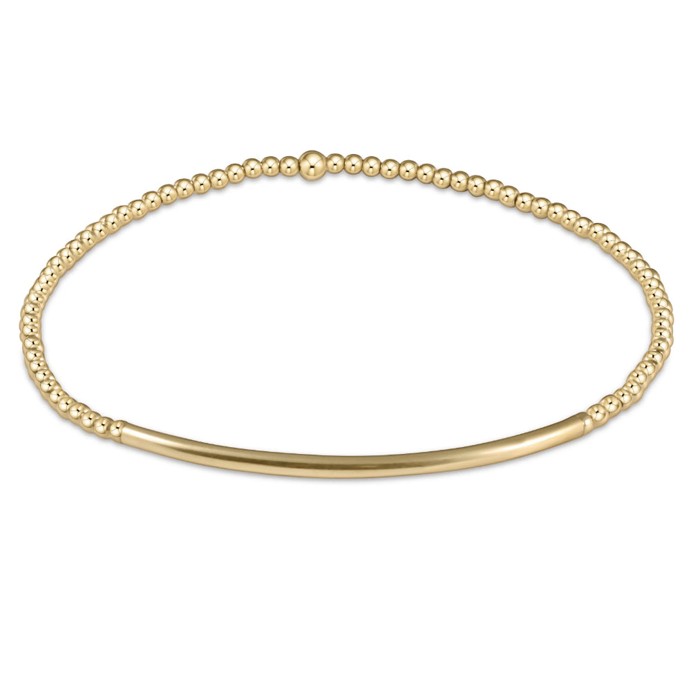 Gold beaded bracelet with smmoth bar on a white background