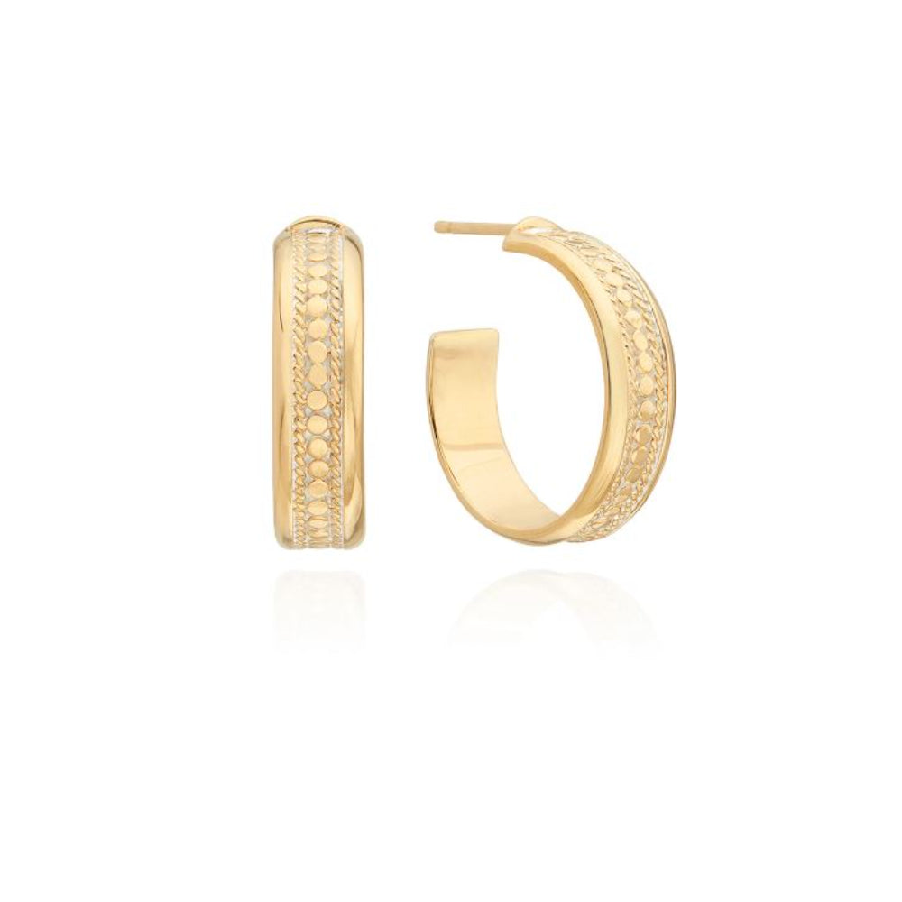 A pair of gold-colored hoop earrings with a textured surface, displayed against a white background.