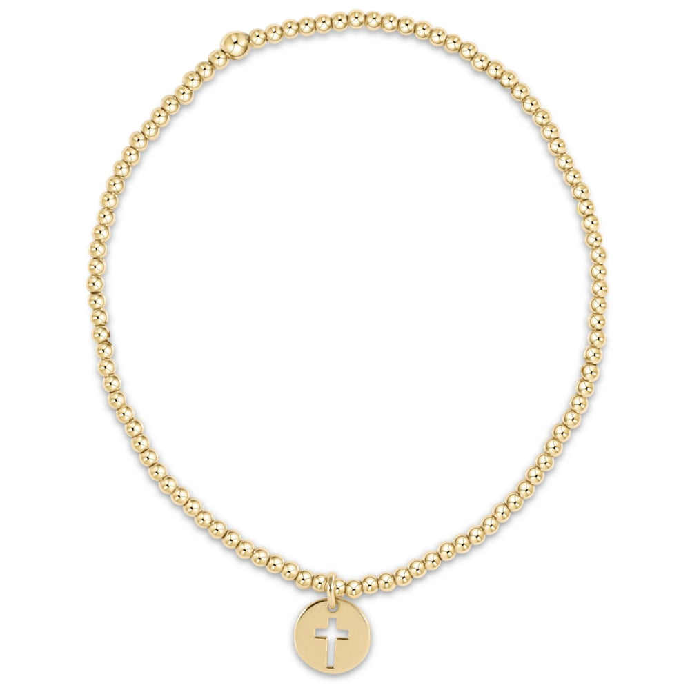 Gold beaded bracelet with a cross charm on a white background