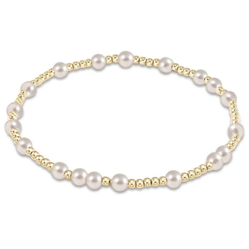 Gold bracelet with pearl accents on a white background