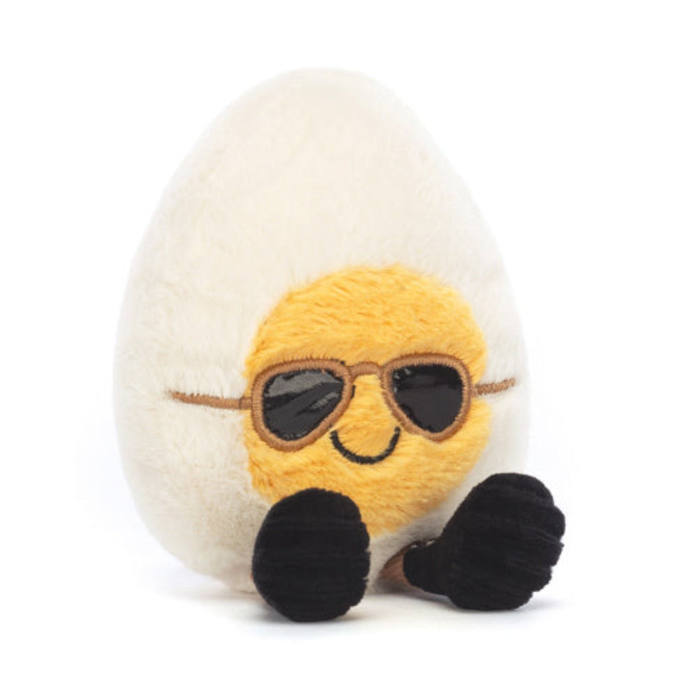 Plush toy resembling a boiled egg with a face wearing sunglasses on a white background