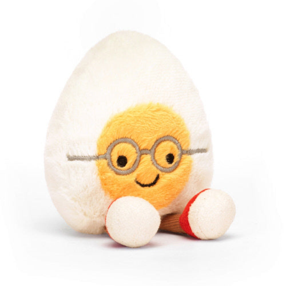 Plush toy resembling a boiled egg with a face wearing glasses on a white background