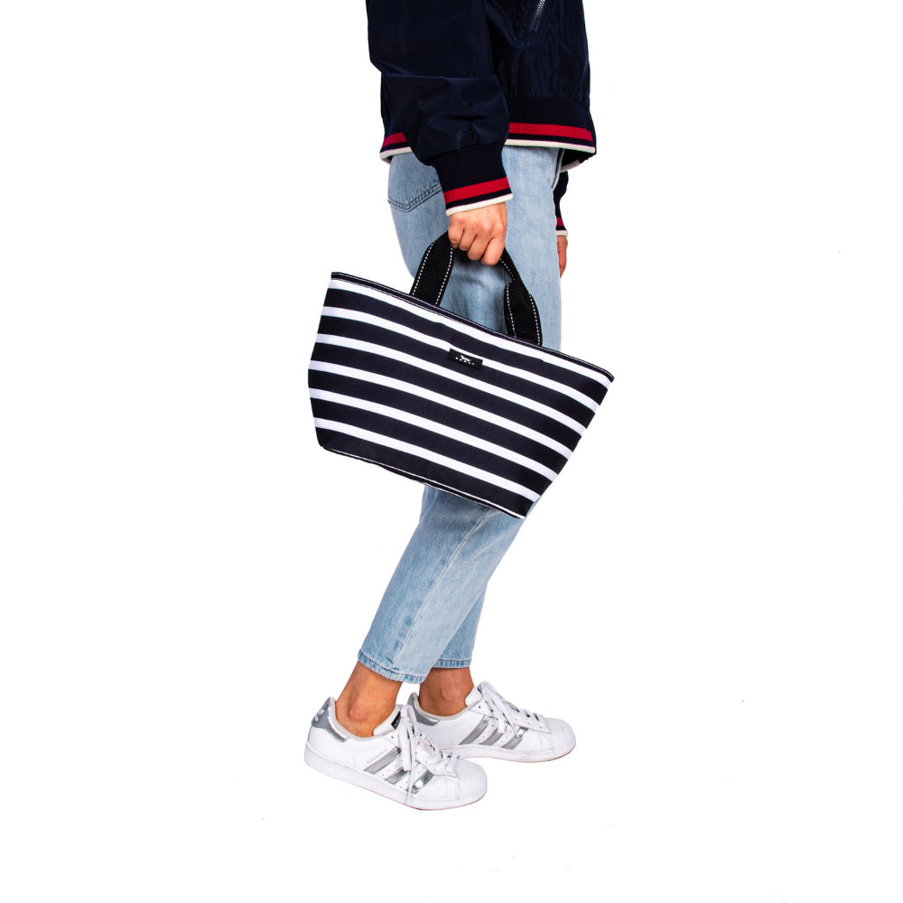 Person holding Scout striped lunch bag on white background. 