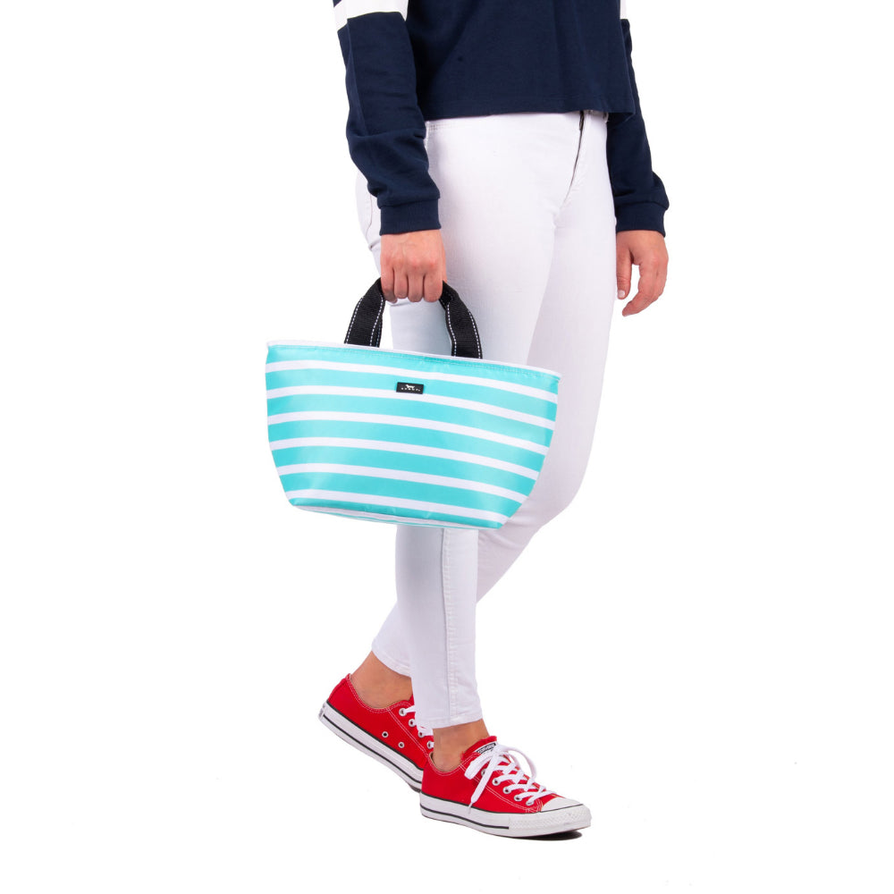 Person displaying and featuring teal and white striped lunchbox with handles on white background. 